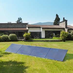 Panneau solaire sur l'herbe devant une maison