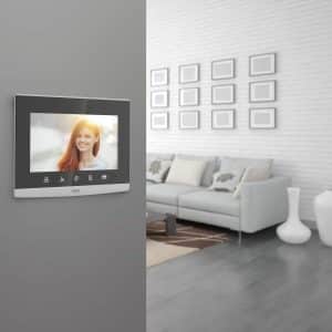 Modern loft living room interior with monochromatic white decor, a comfortable modular lounge suite and rug and accent bookcases with structural ceiling beams